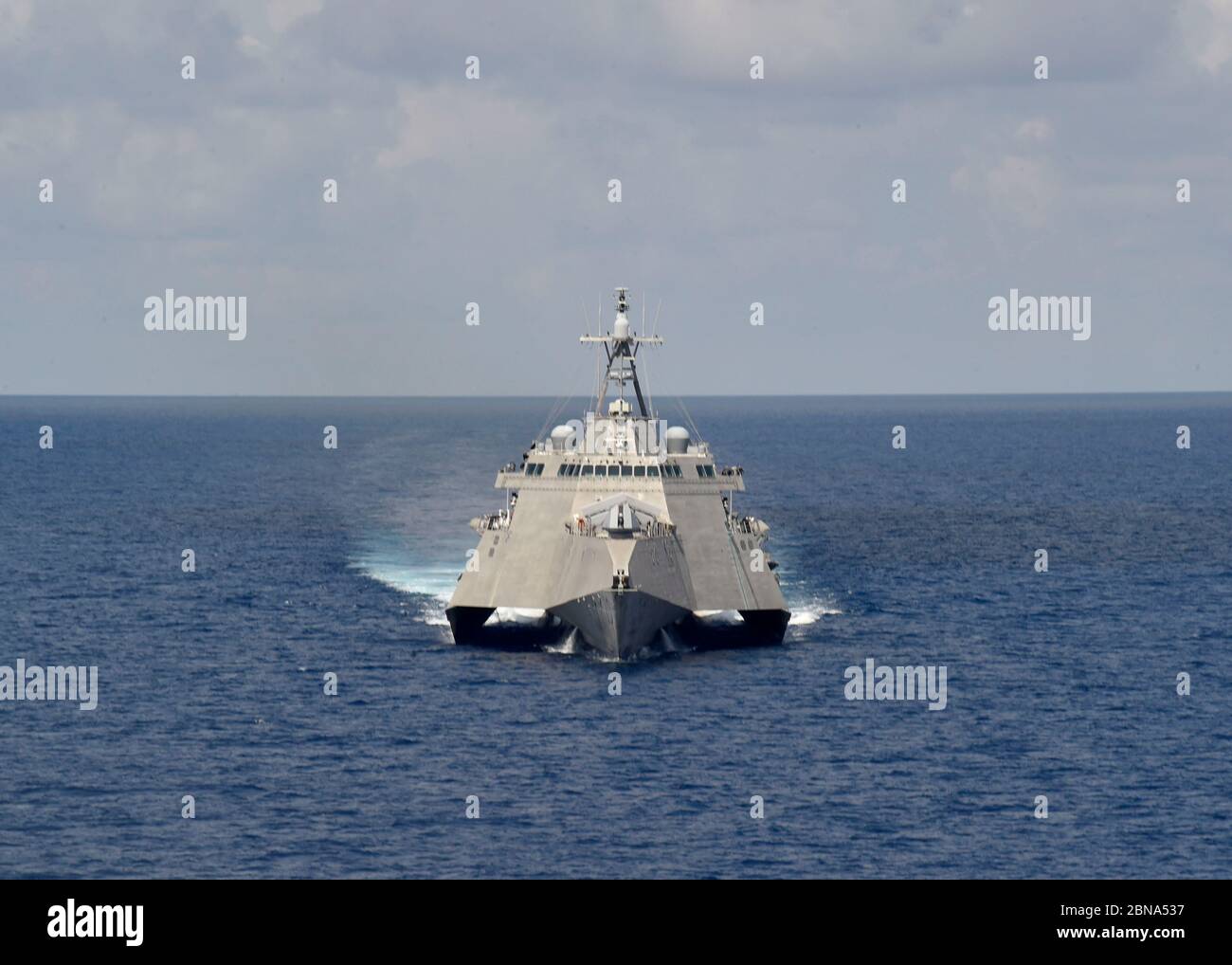 The U.S. Navy Independence-variant littoral combat ship USS Gabrielle Giffords patrols near the Panamanian flagged drill ship, West Capella which has been harassed by Chinese forces for drilling in disputed waters May 12, 2020 in the South China Sea. Stock Photo