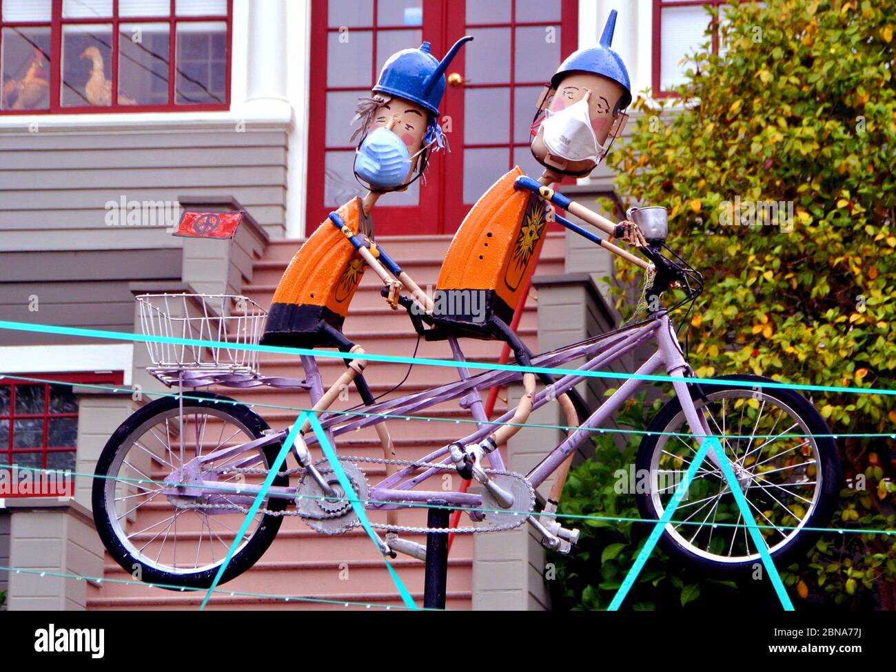 home owner decorates bycycle  with coronavirus masks Stock Photo