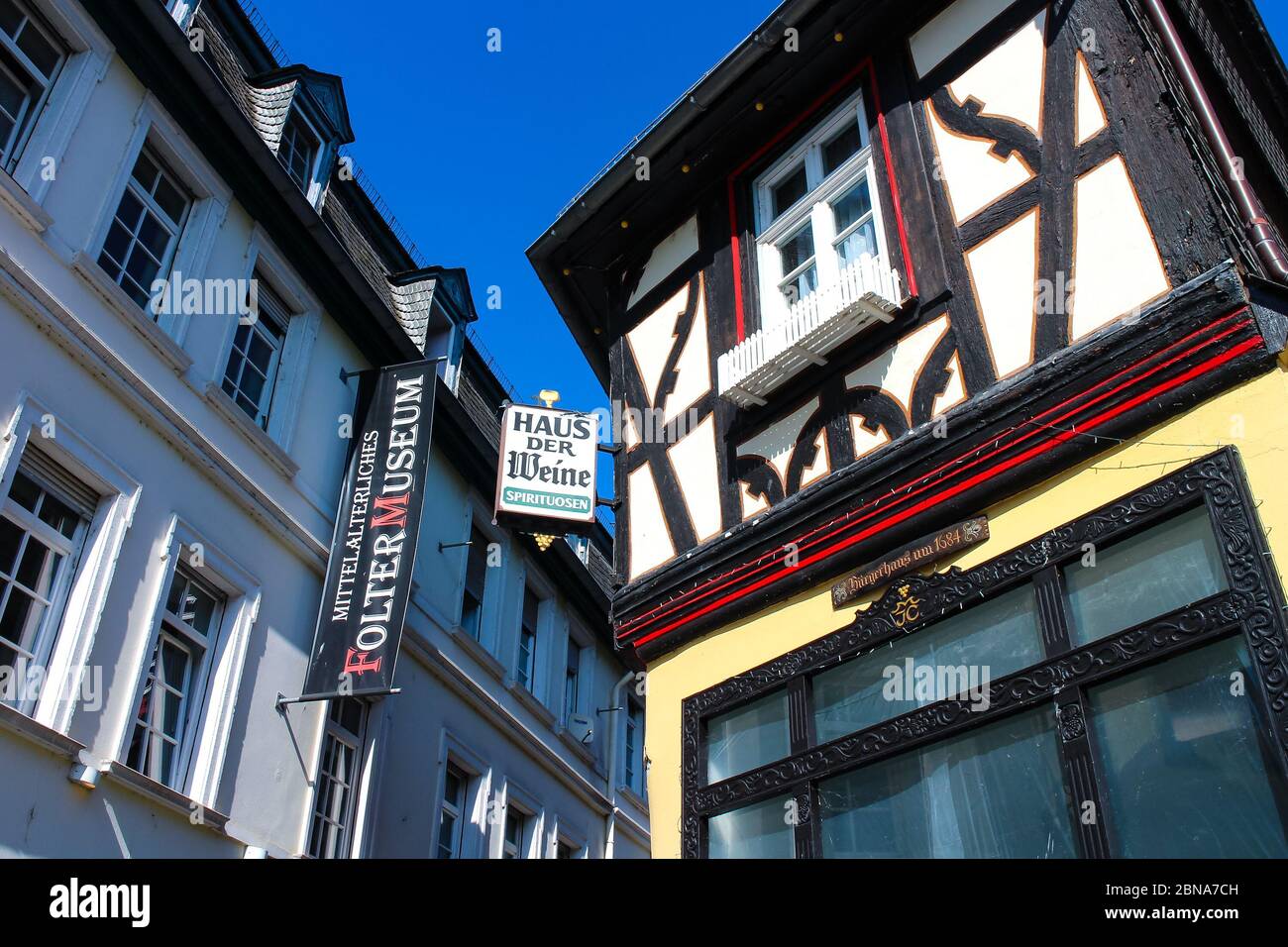 Rüdesheim, Germany historical buildings with German-language signs for both a 'House of Wines ' and a 'Medieval Torture Museum '. Stock Photo