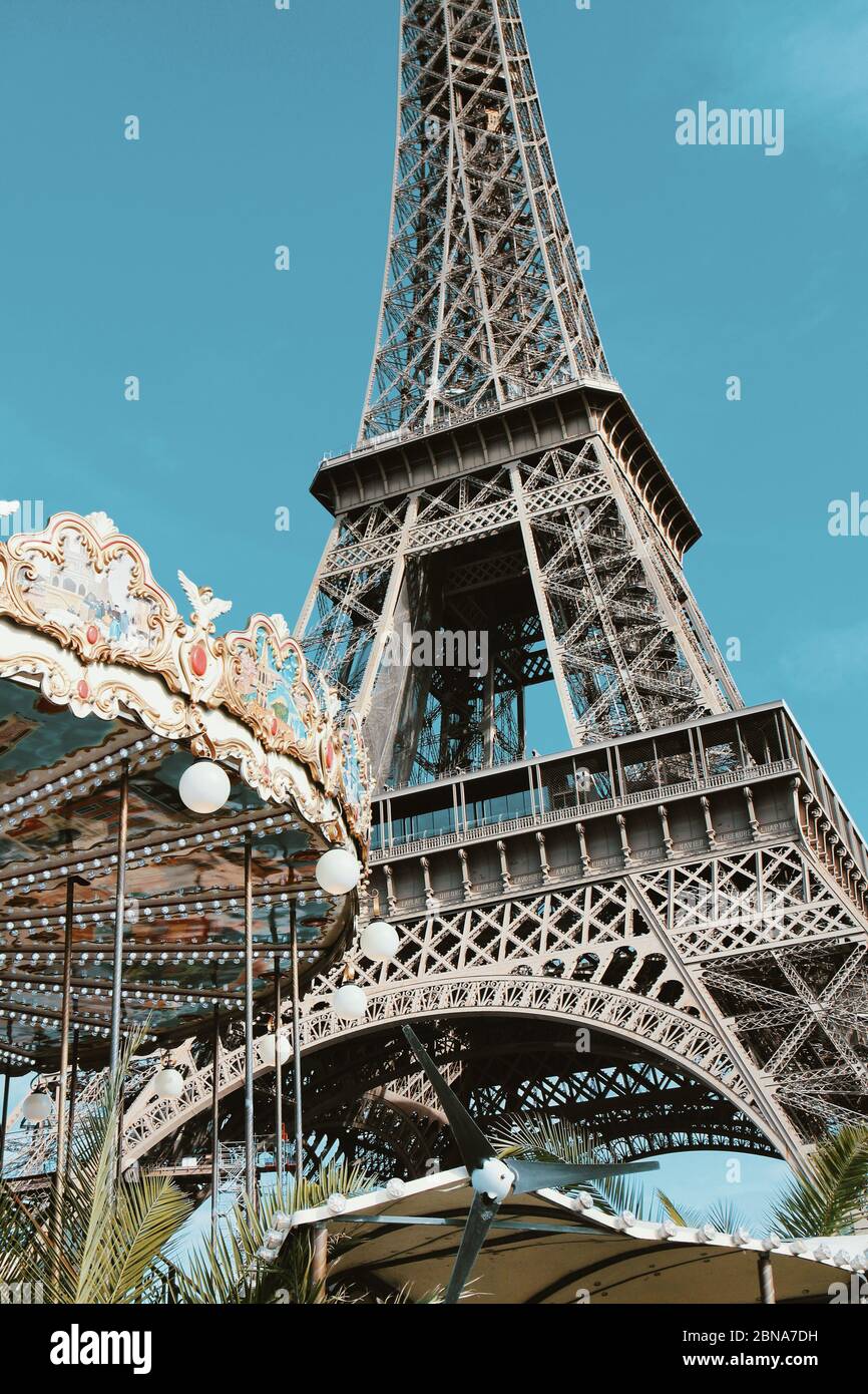 Retro colors Eiffel Tower with an old-fashioned nostalgic merry-go-round in Paris, France. Stock Photo