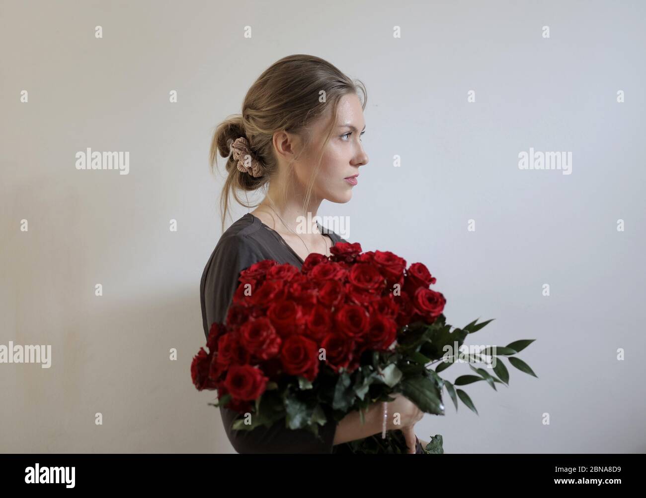 Young beautiful woman holding red roses Stock Photo - Alamy