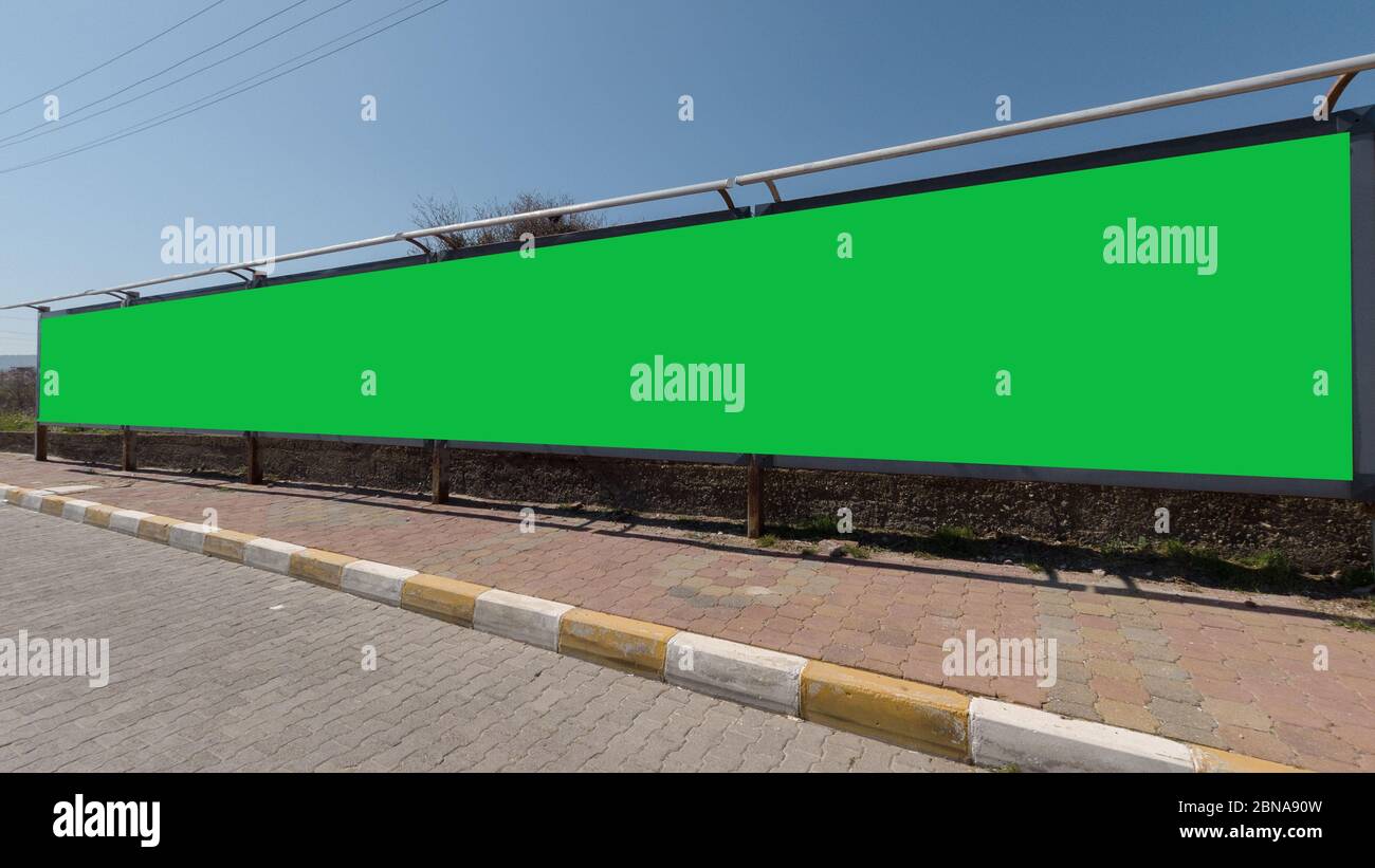 Long green screen for ads at the side of a road, an excellent space for  your text Stock Photo - Alamy