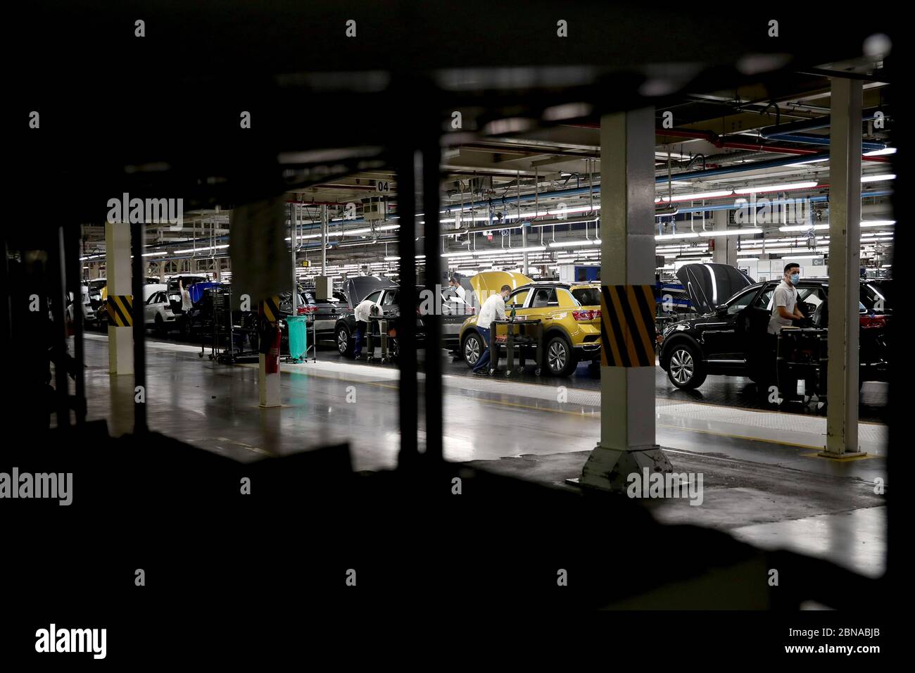 Lisbon, Portugal. 13th May, 2020. Employees wearing face masks work on the assembly line at the Volkswagen Autoeuropa car factory in Palmela, Portugal, May 13, 2020. Portuguese President Marcelo Rebelo de Sousa and Prime Minister Antonio Costa on Wednesday encouraged all industries to restart under strict conditions amid the COVID-19 pandemic, Lusa News Agency reported. After their joint visit to automotive assembly plant Autoeuropa, the two leaders expressed their confidence in the resumption of production for the car producer. Credit: Pedro Fiuza/Xinhua/Alamy Live News Stock Photo