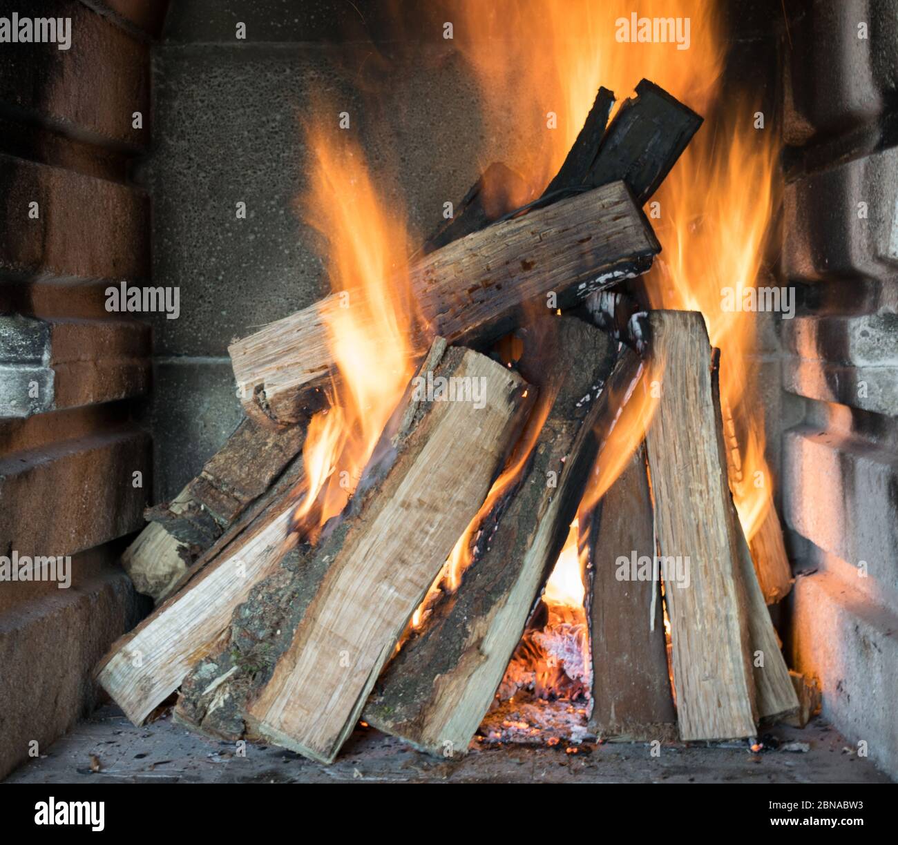 Beautiful shot of burning wood logs creating amazing orange flames Stock Photo