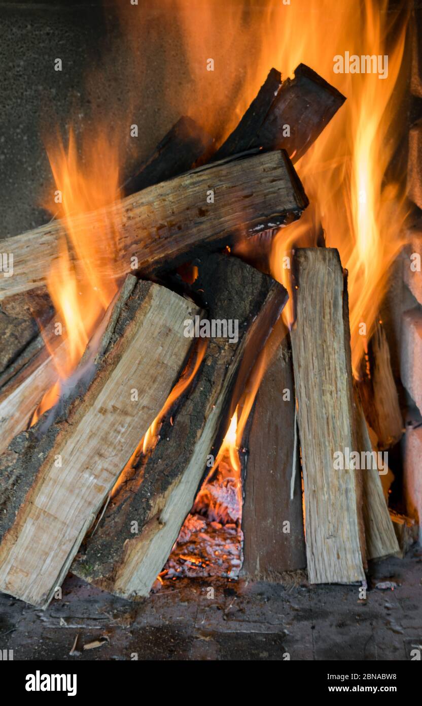 Beautiful shot of burning wood logs creating amazing orange flames Stock Photo