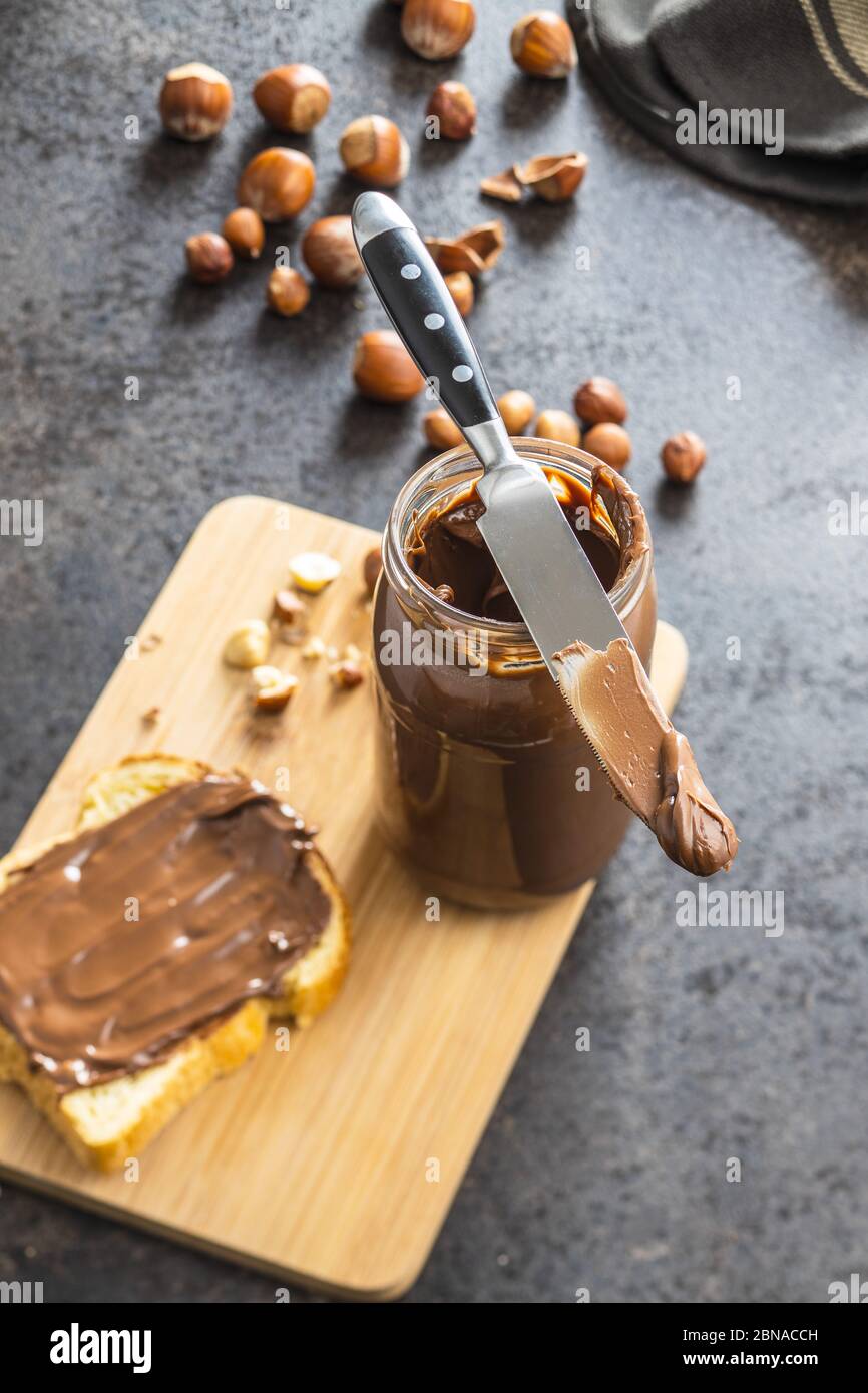 Hazelnut spread and toast bread. Chocolate cream on cutting board Stock