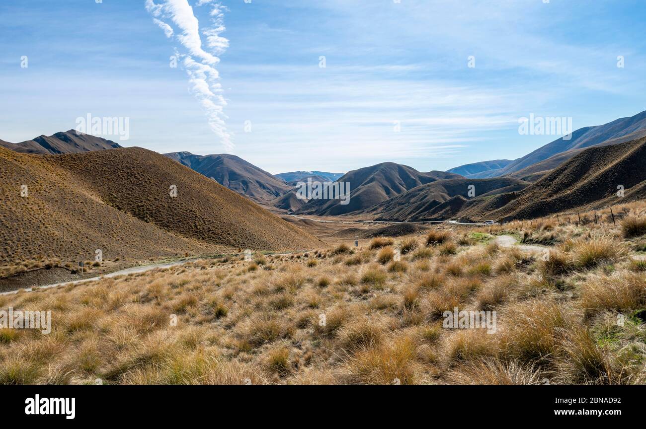 Barren mountain landscape with tufts of grass, Lindis Pass, Southern Alps, Otago, South Island, New Zealand, Oceania Stock Photo