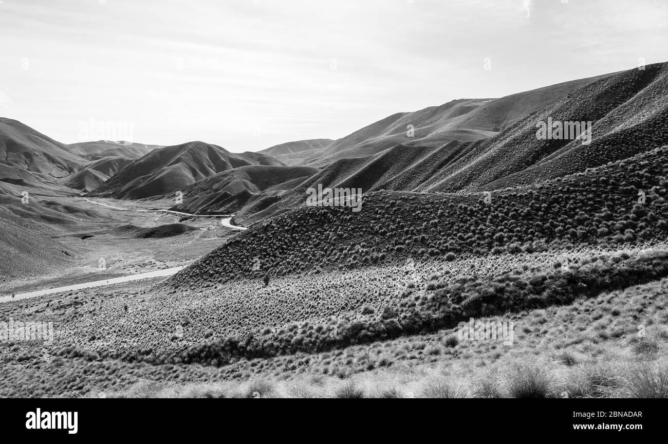 Black and white photo, barren mountain landscape with pass road, Lindis Pass, Southern Alps, Otago, South Island, New Zealand, Oceania Stock Photo