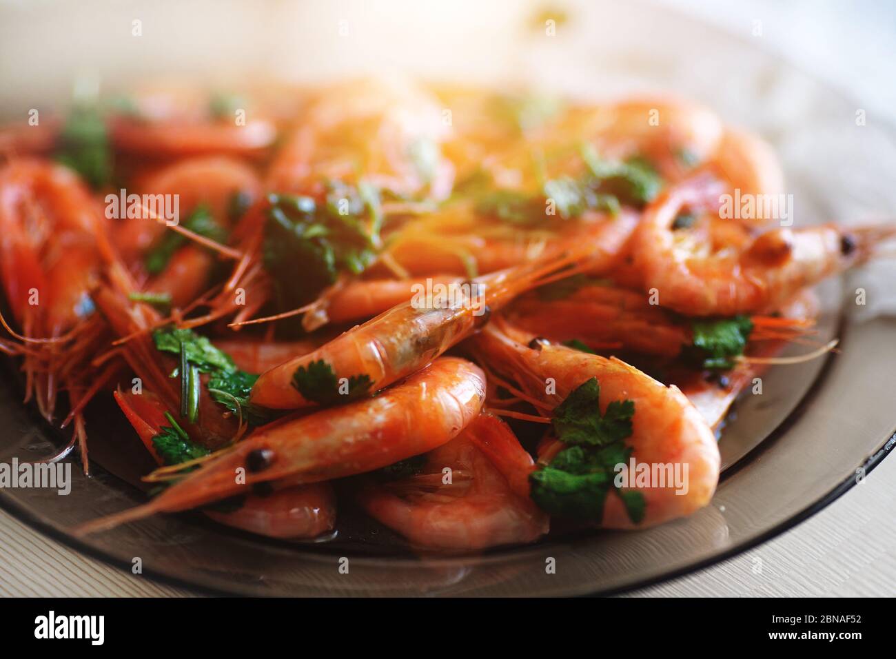 Delicious prawns with coriander in a plate on the table. Fresh seafood dish close-up Stock Photo