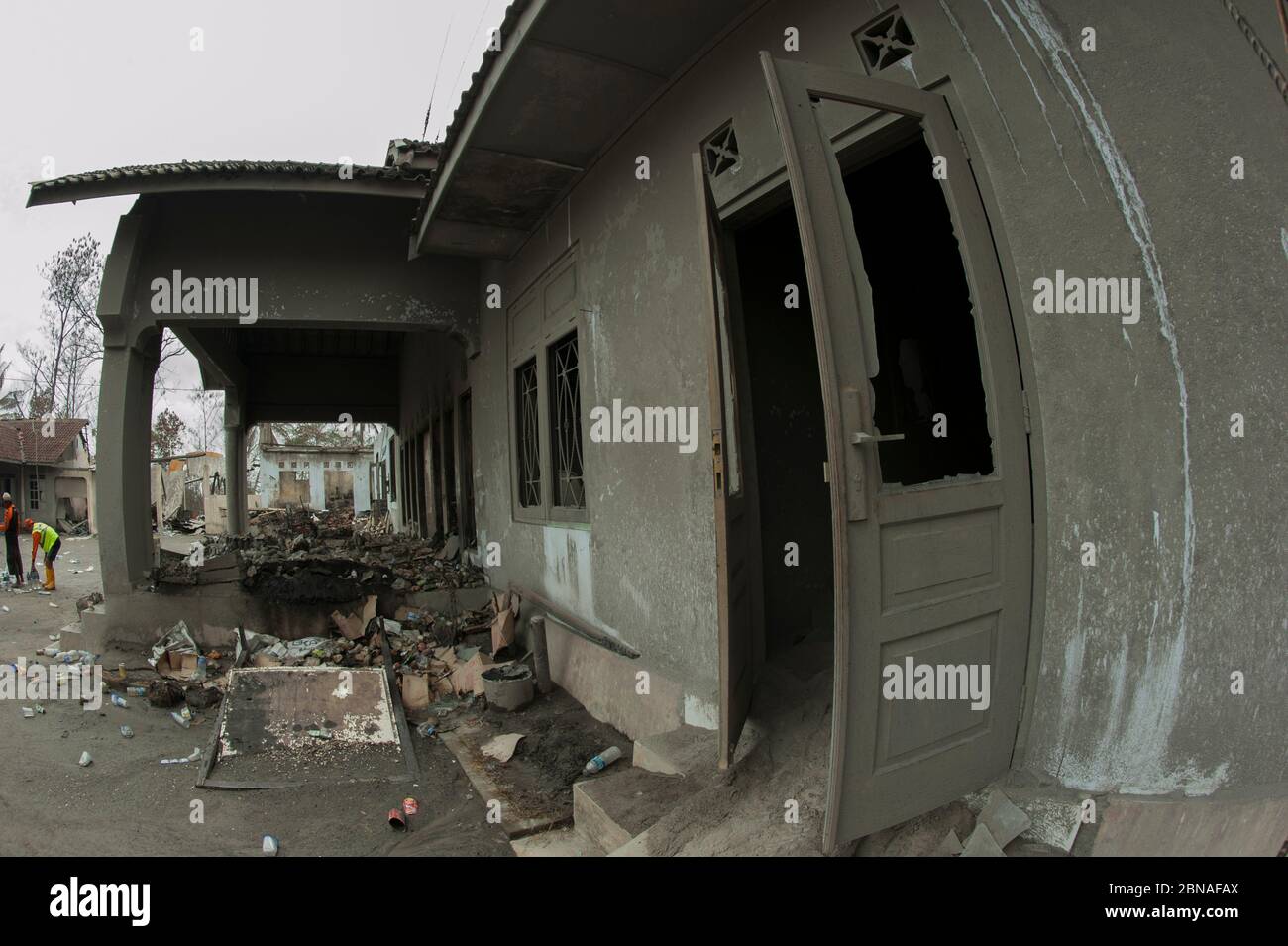 Debris and damaged house from ash from Mount Merapi volcano eruption inside 5 km evacuation zone, Kepuharjo, near Jogyakarta, Central Java, Indonesia Stock Photo