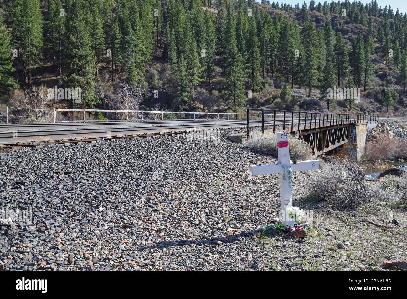 FLORISTON, CALIFORNIA, UNITED STATES - Apr 12, 2020: A memorial marker sits beside a set of railroad tracks, reminding people of the dangers in being Stock Photo