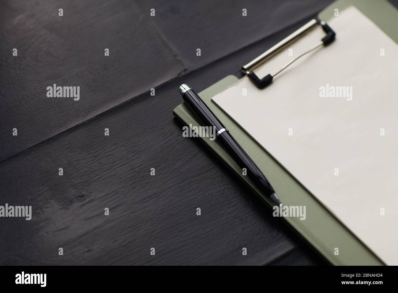 Close-up of blank paper on the clipboard with pen on the wooden table Stock Photo