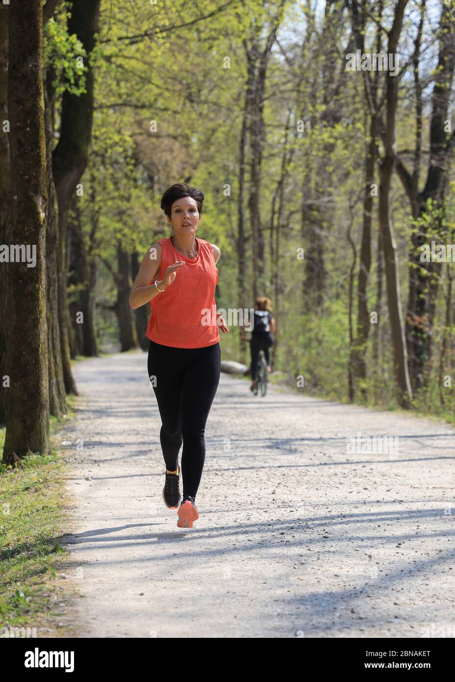 Woman, 40-45 years old, jogging in a forest area in Munich, Bavaria, Germany. Stock Photo