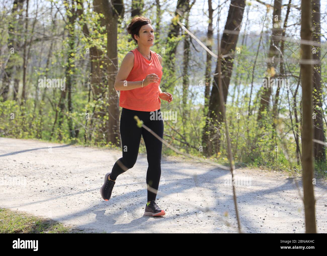 Woman, 40-45 years old, jogging in a forest area in Munich, Bavaria, Germany. Stock Photo