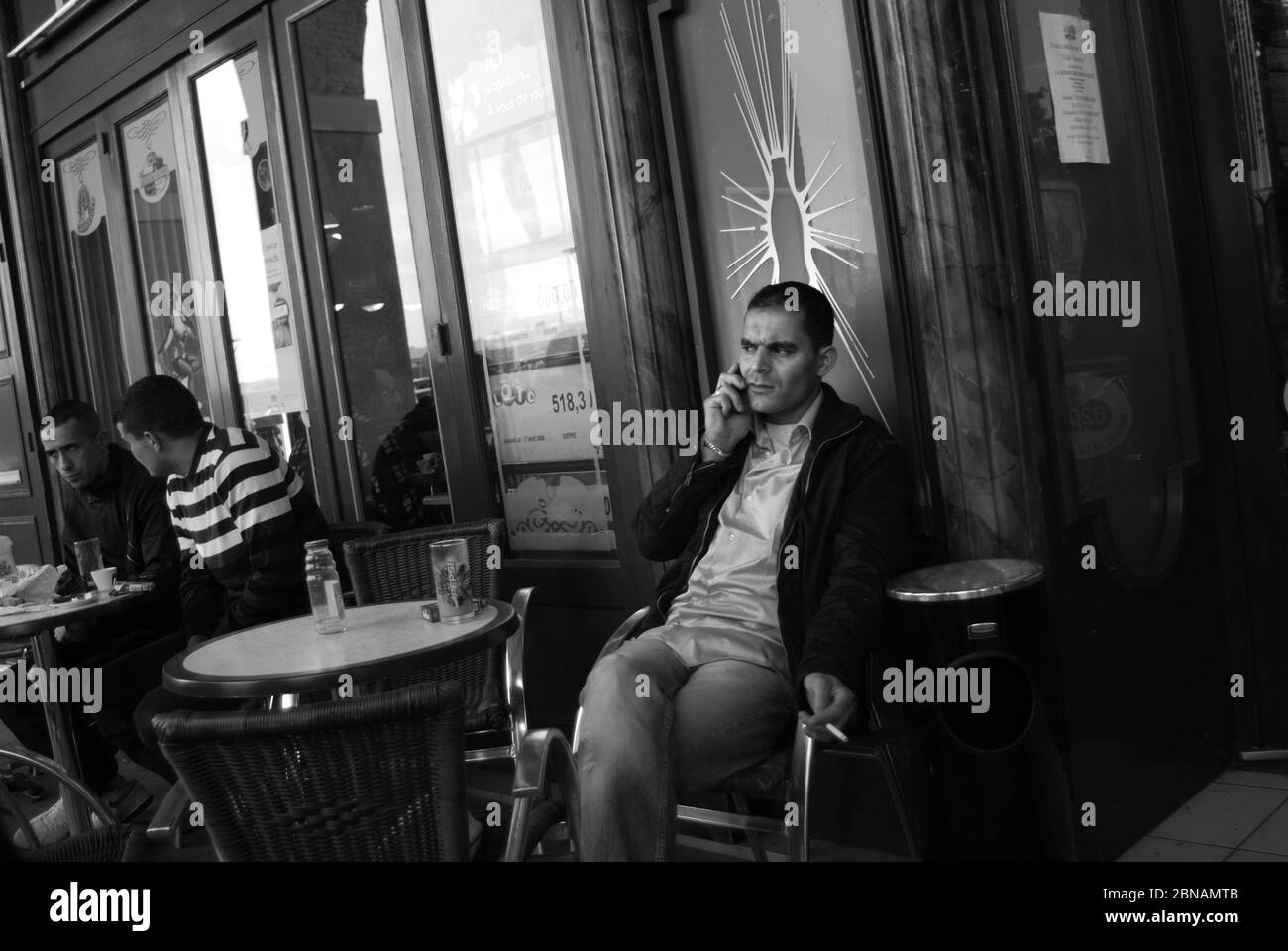 Man at cafe talking on mobile phone, Port of Dieppe, Normandy Stock Photo