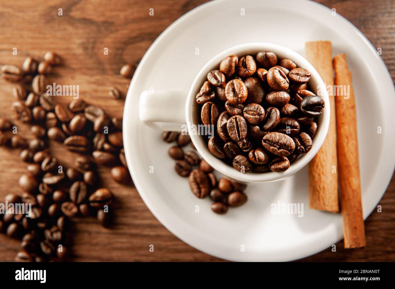 Coffee cup with cinnamon sticks and beans view from above Stock Photo