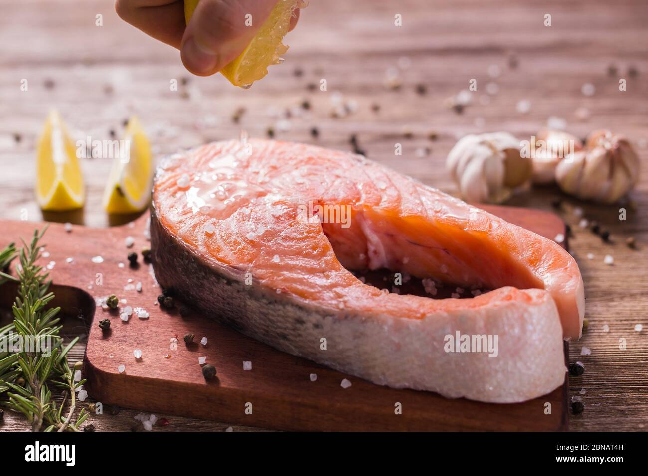 Fish Menu. Cook man plating salmon steak squeezing lemon juice. Selective Focus Stock Photo
