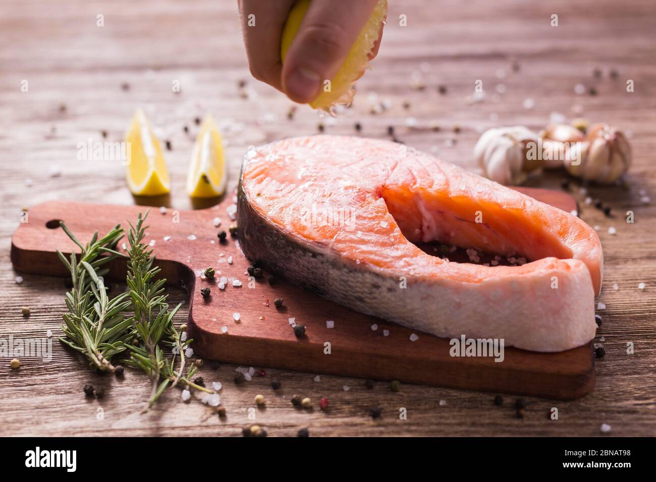 Fish Menu. Cook man plating salmon steak squeezing lemon juice. Selective Focus Stock Photo