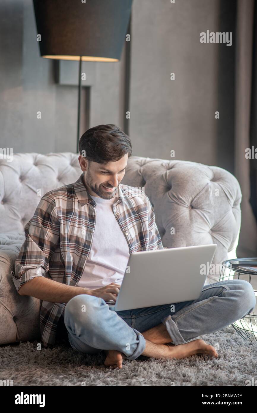 Man with a laptop sitting on the floor Stock Photo - Alamy