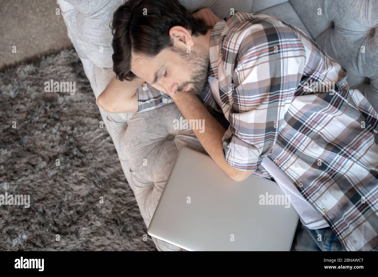Bearded man in a plaid shirt sleeping at home. Stock Photo
