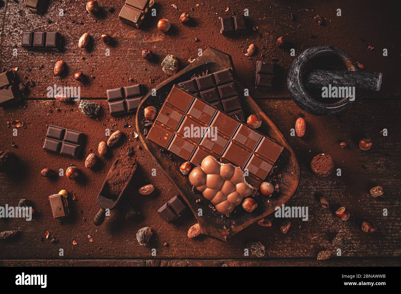 Flat lay of dark chocolate chunks and beans on wooden table Stock Photo