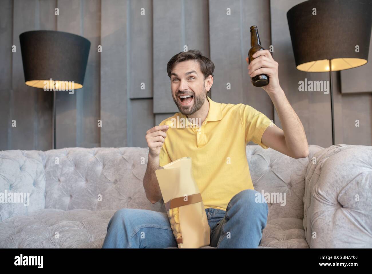 Young joyfully screaming man with raised hand Stock Photo