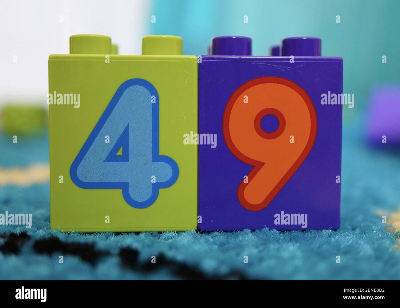 POZNAN POLAND Apr 23 2015 Plastic Lego Duplo green and purple toy blocks with number four and nine on a carpet floor in soft focus background Stock Photo Alamy