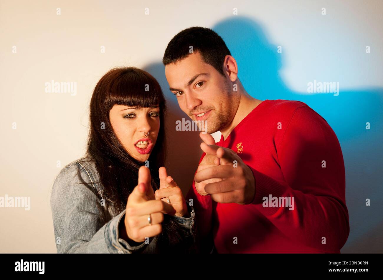 Young couple looking and pointing at the camera. Stock Photo