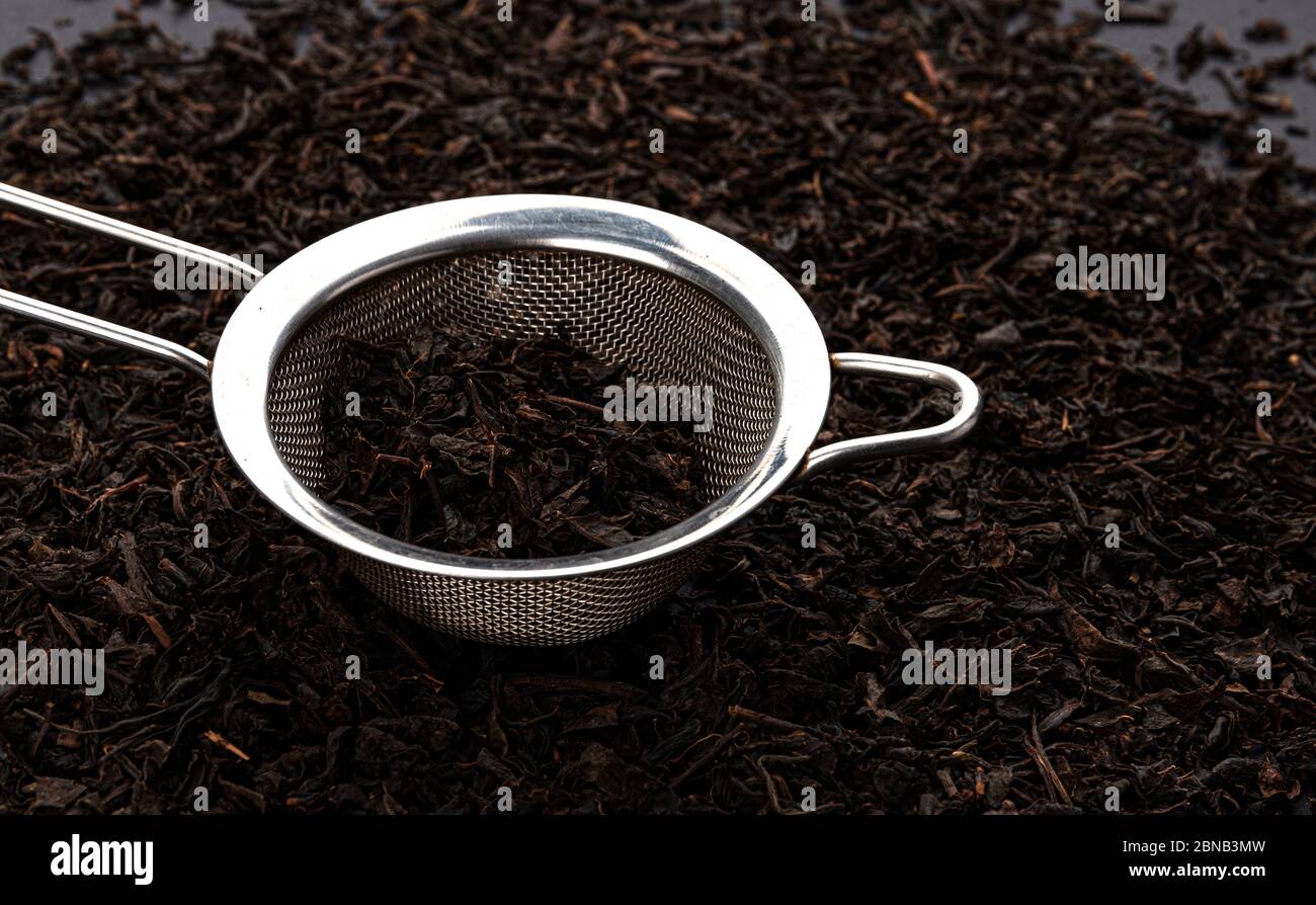 Metal tea strainer with dry black tea leaves Stock Photo Alamy