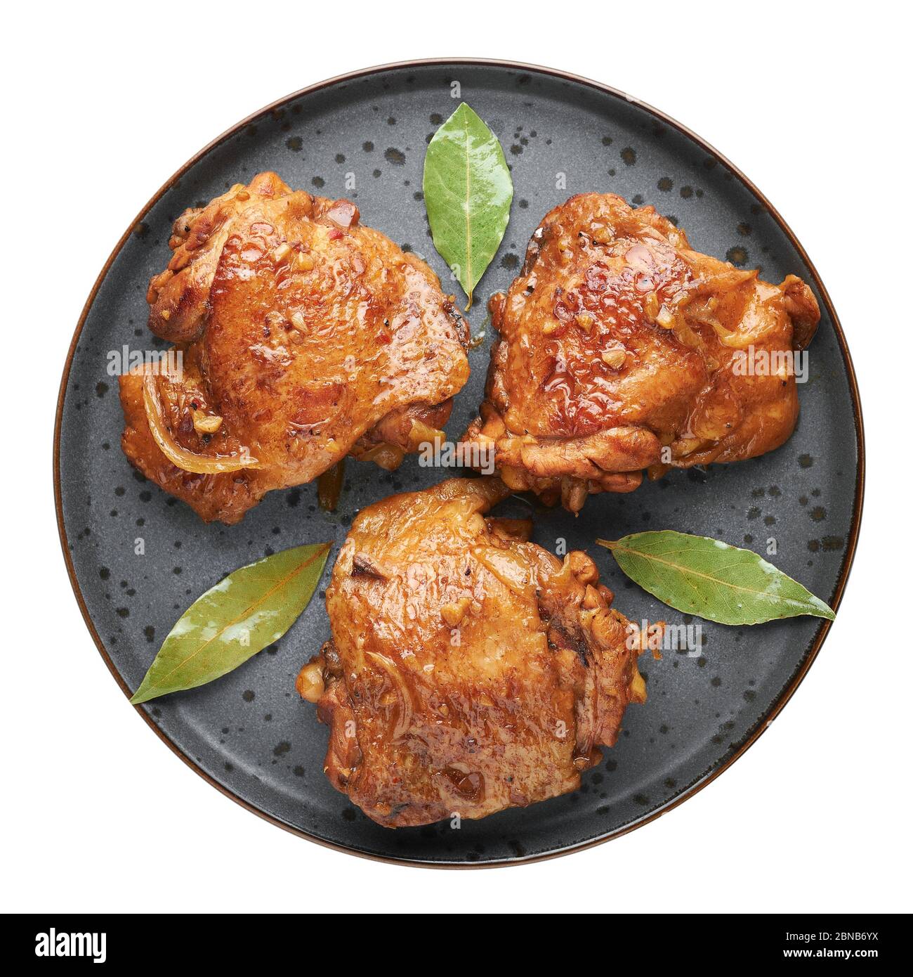 Filipino Chicken Adobo on dark gray plate isolated on white backdrop