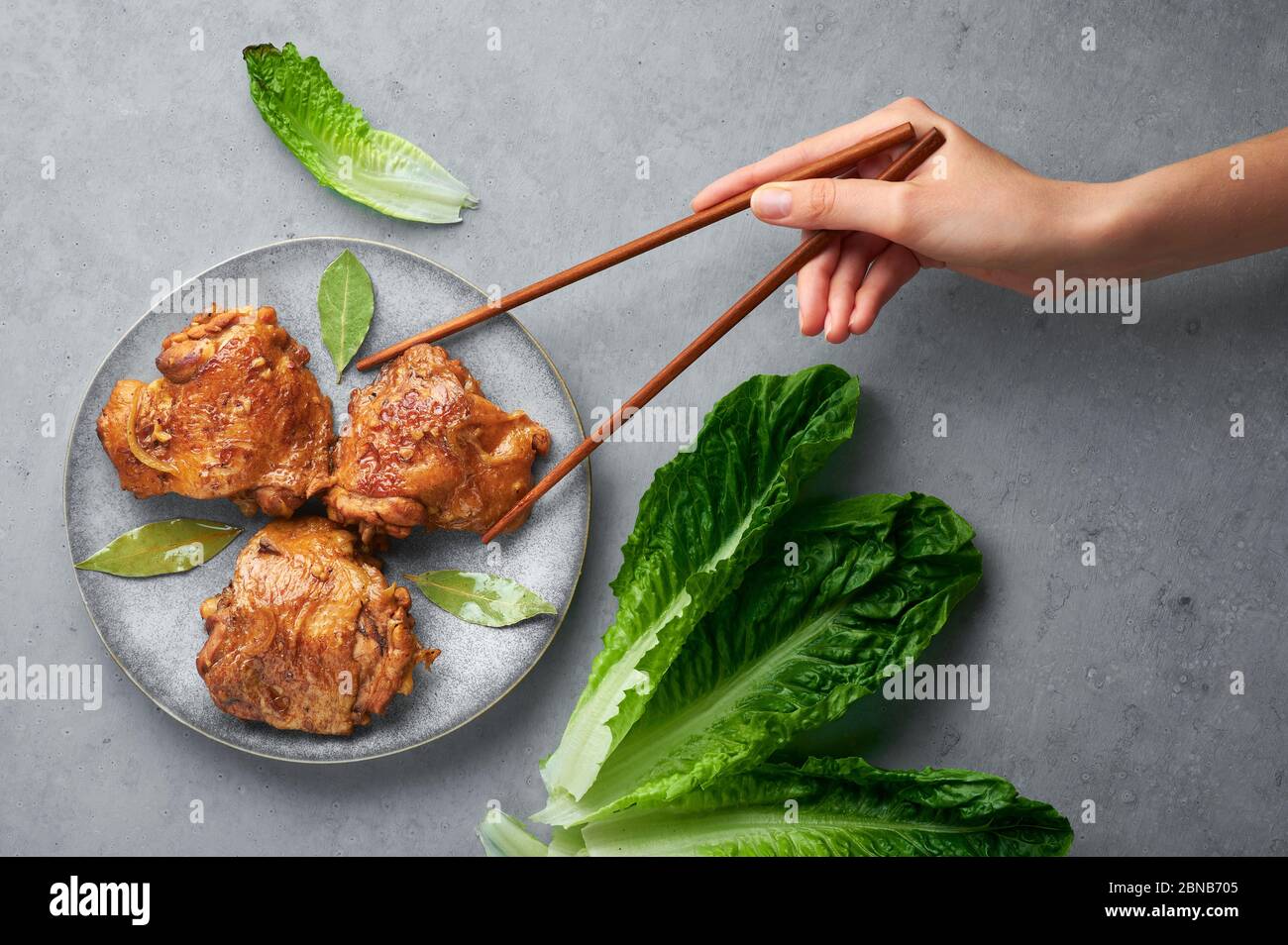 Filipino Chicken Adobo on gray plate on concrete backdrop. Chicken