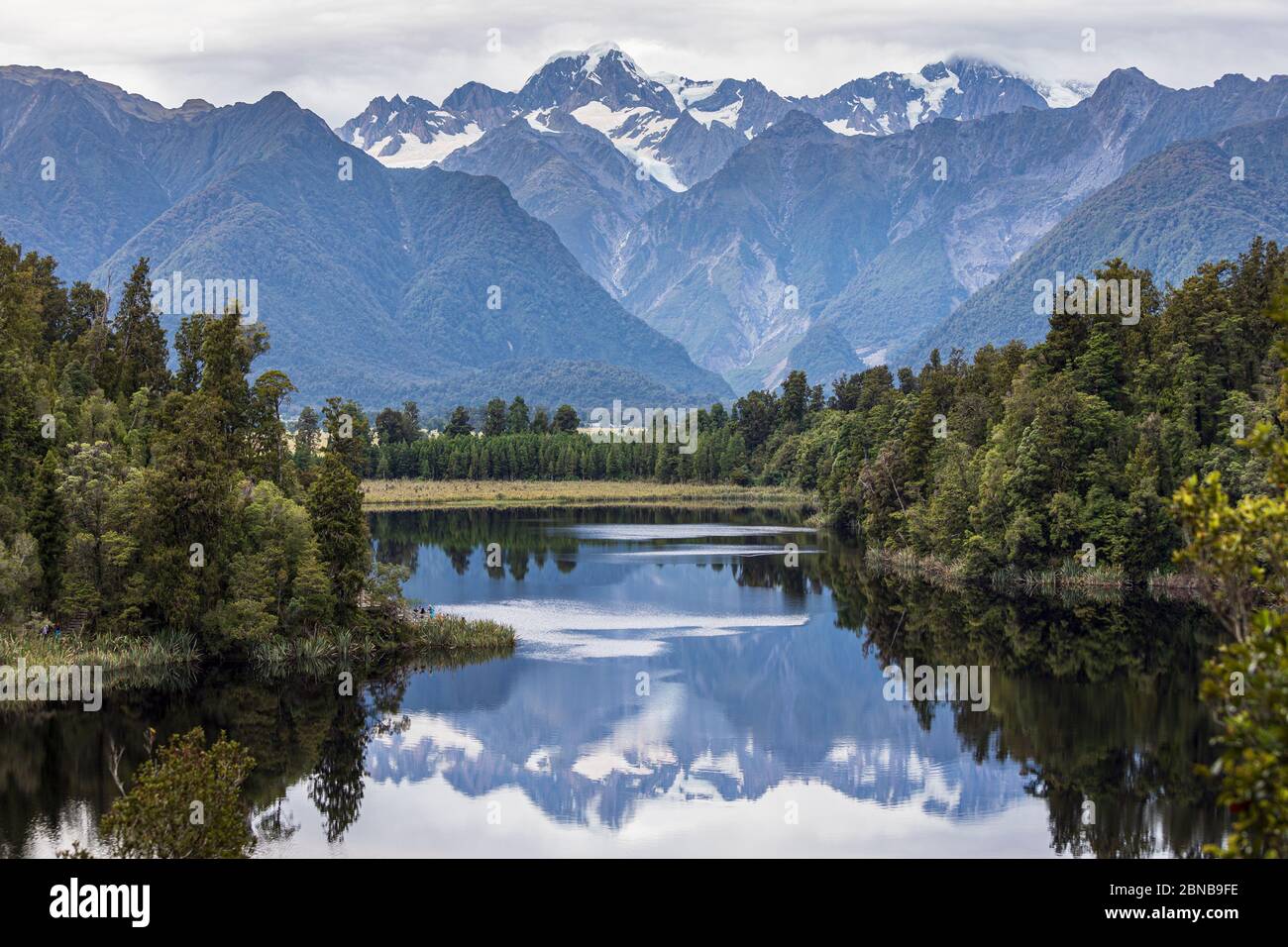 The 'View of Views' - Lake Matheson looking towards Mount Tasman and Mount Cook, Fox Glacier, South Island, New Zealand Stock Photo