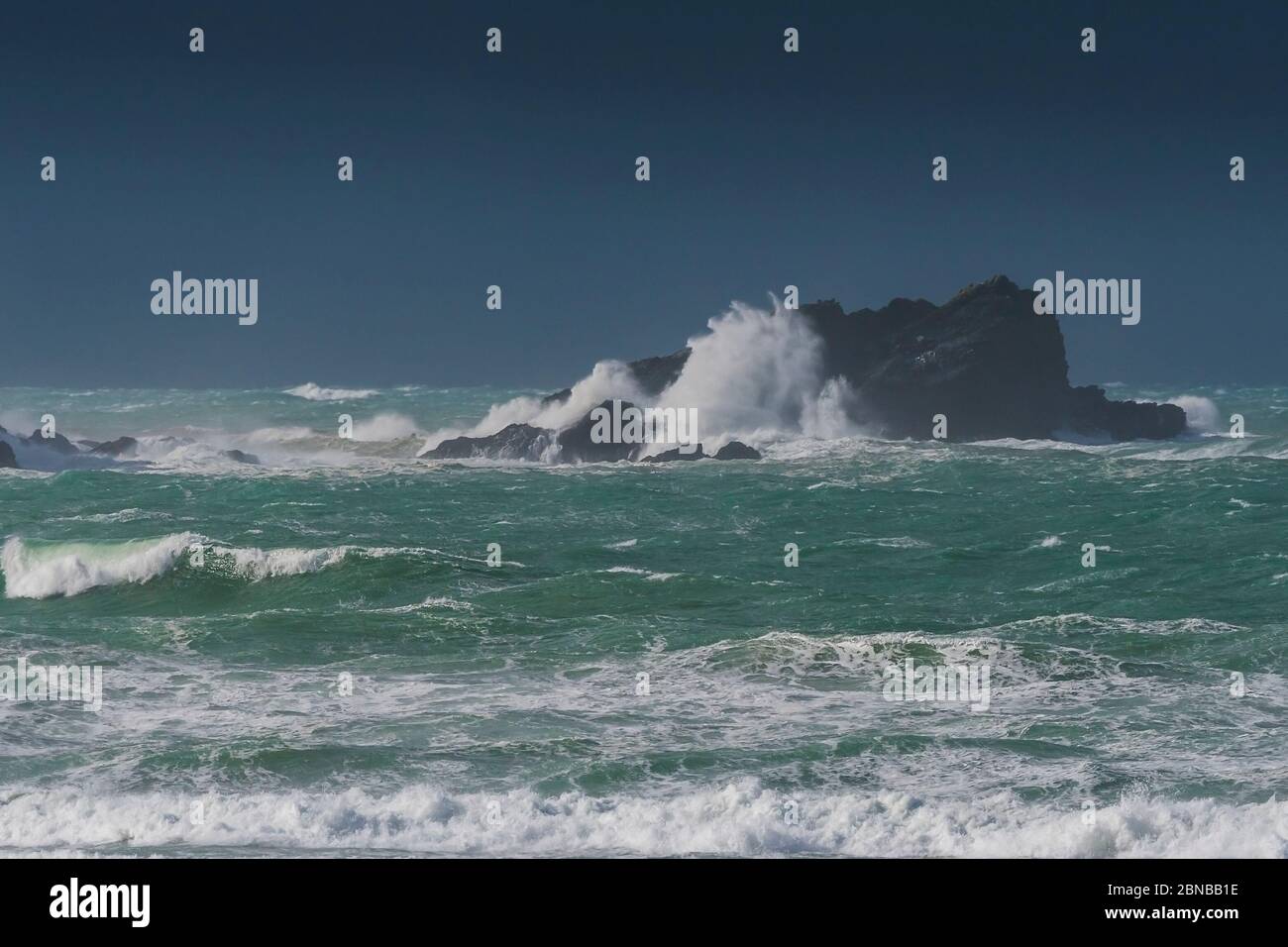 Wild stormy sea conditions as waves crash against Goose Island The Goose off the coast of Newquay in Cornwall. Stock Photo