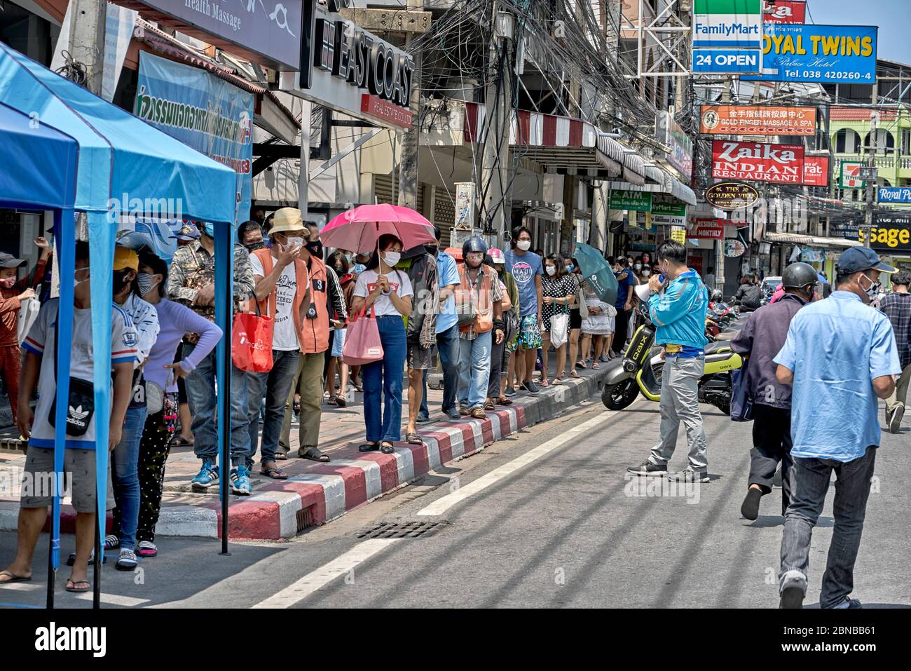 Covid-19 and coronavirus effect on income. People queueing for free food handouts donated by the local businesses in Pattaya Thailand Southeast Asia Stock Photo