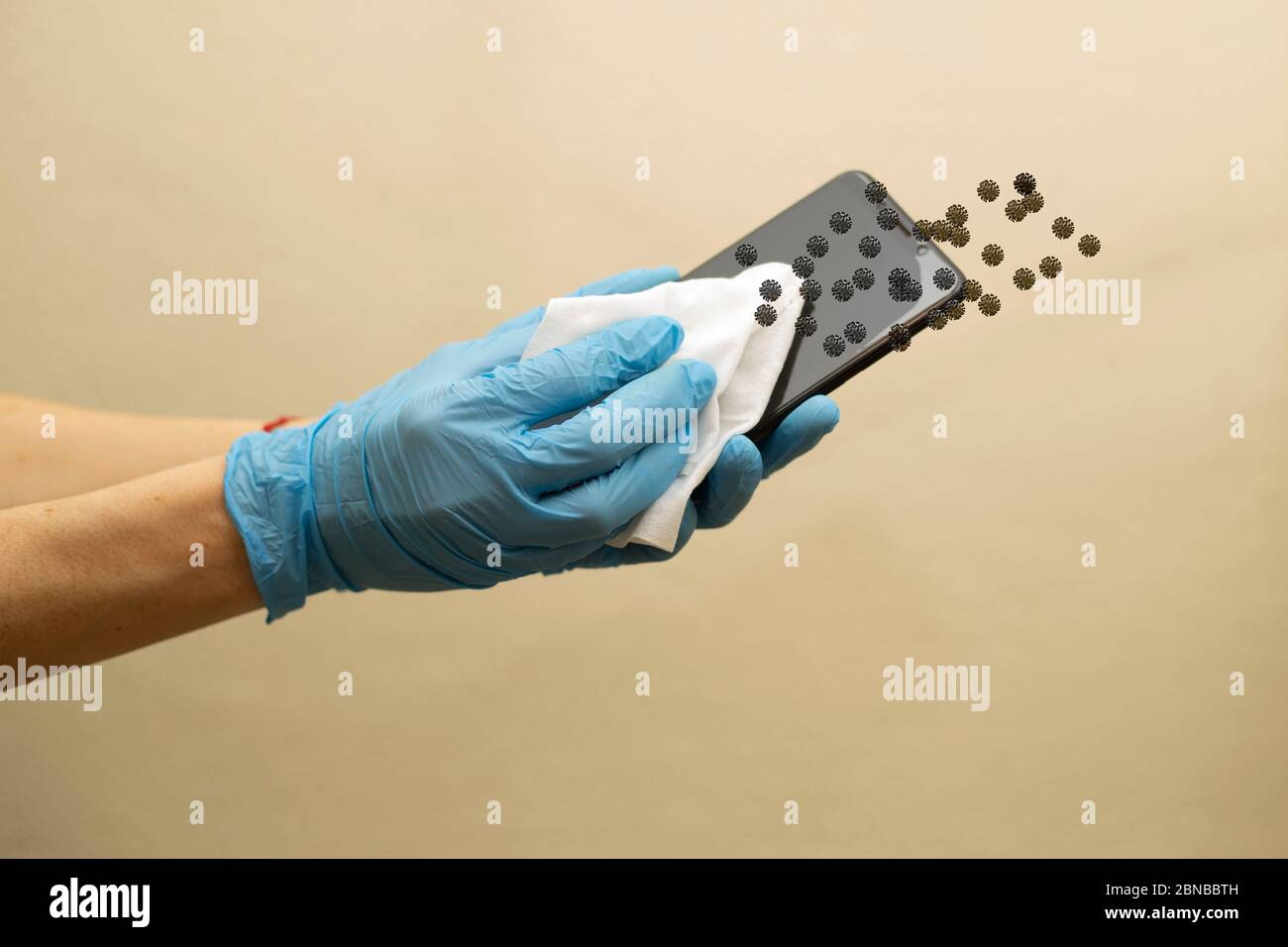 Woman wiping srmartphone in house and using disinfectant wipe. Stock Photo