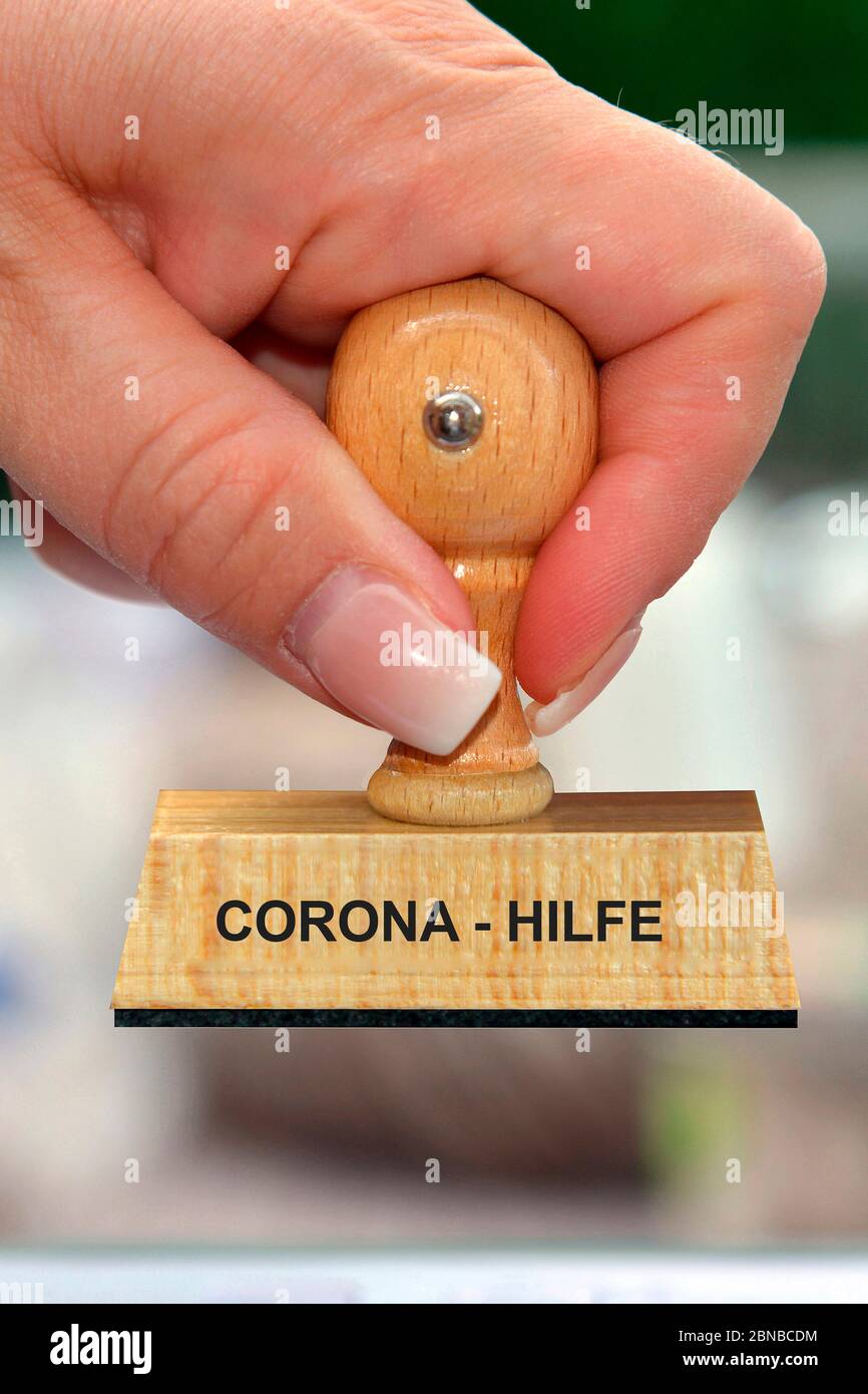 stamp in the hand of a woman lettering Corona-Hilfe, Corona aid, Germany Stock Photo