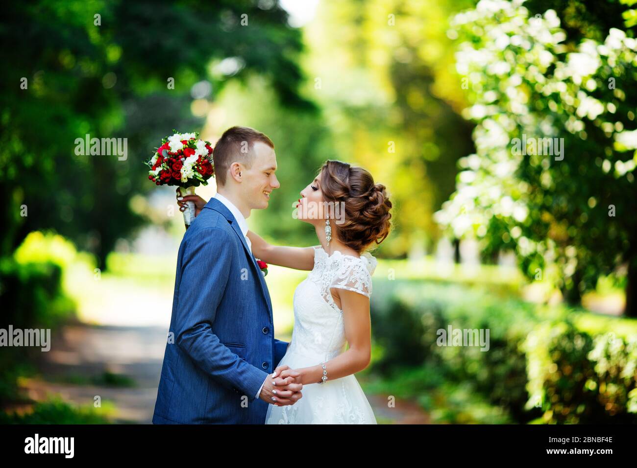 Wedding couple, happy newlyweds and husband hugging in green park Stock ...