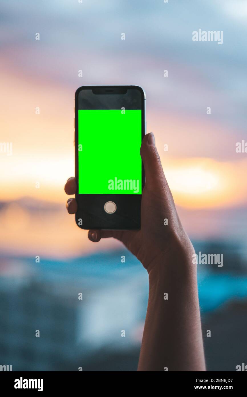 Hand holding a smartphone on a green screen Stock Photo - Alamy