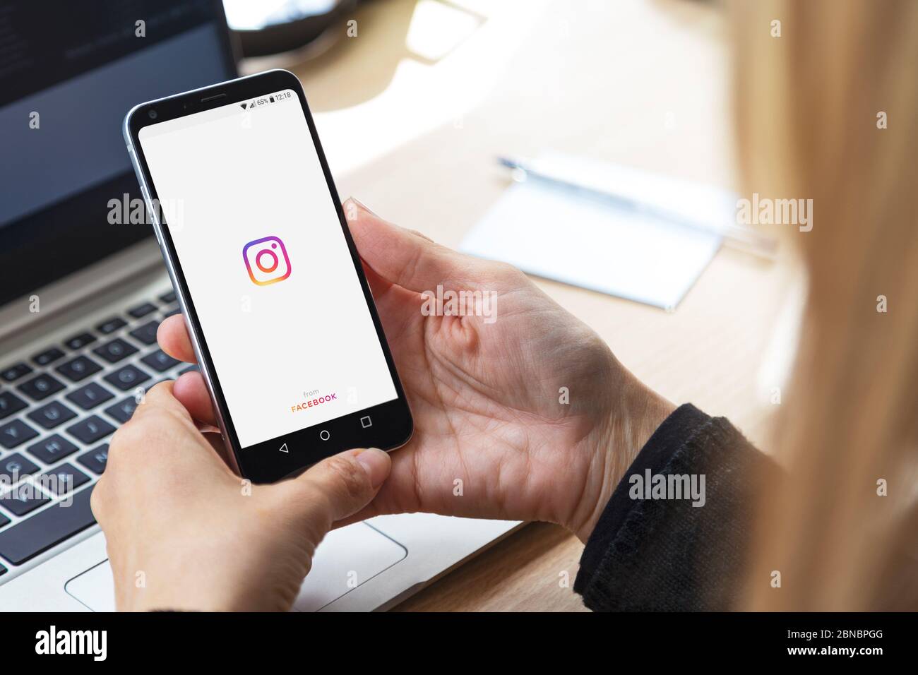 Girl with instagram start screen. She's with smartphone in her hands and a instagram logo on display. Young business Stock Photo