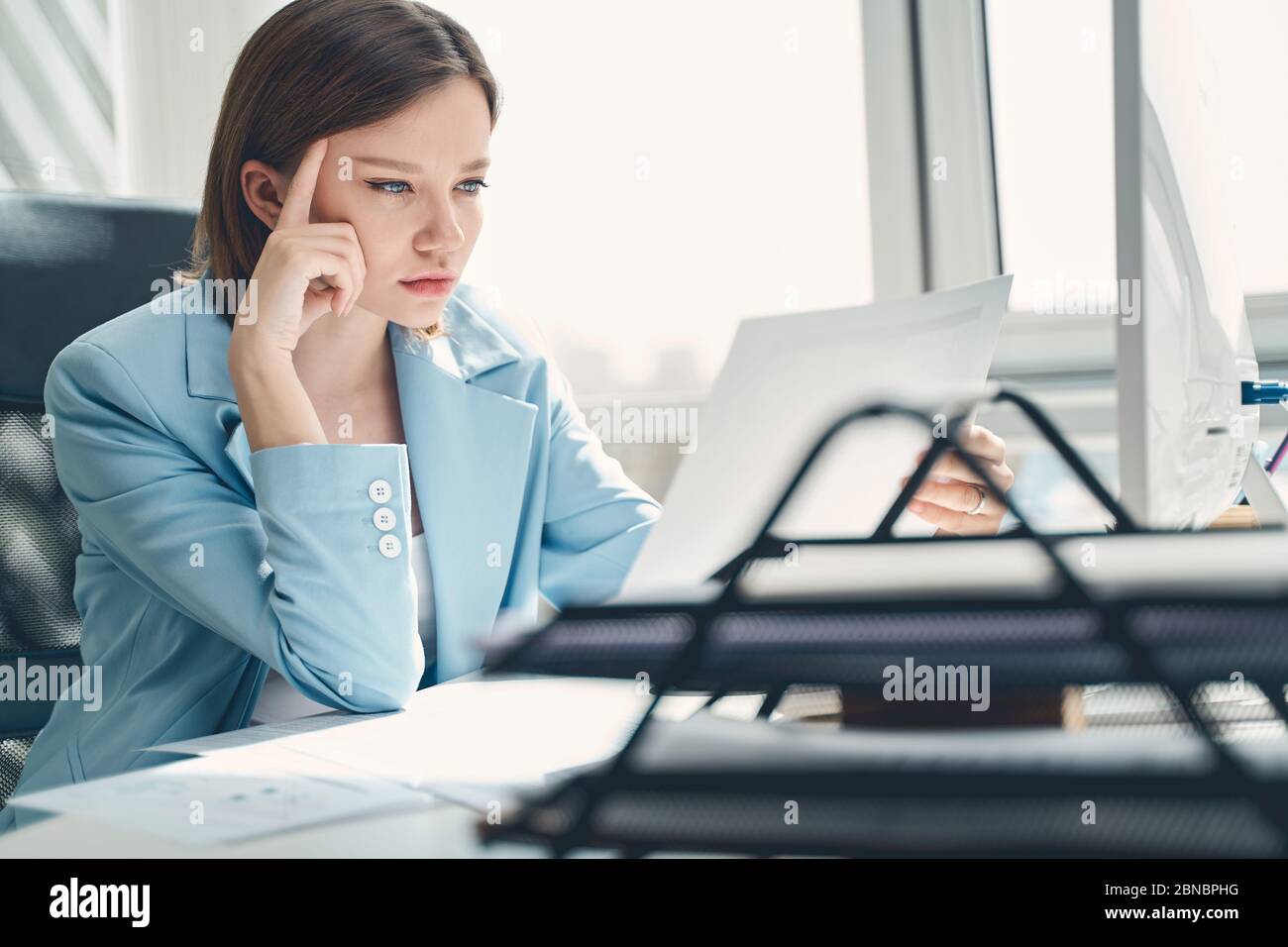 Attractive young lady working in modern office Stock Photo