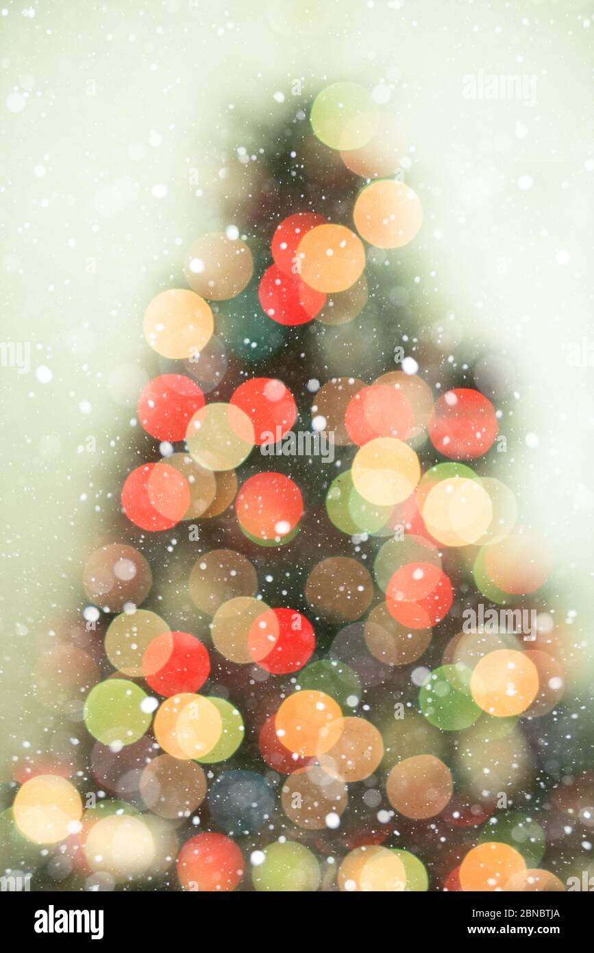 Bokeh christmas tree background with snowfall - defocused lights Stock Photo