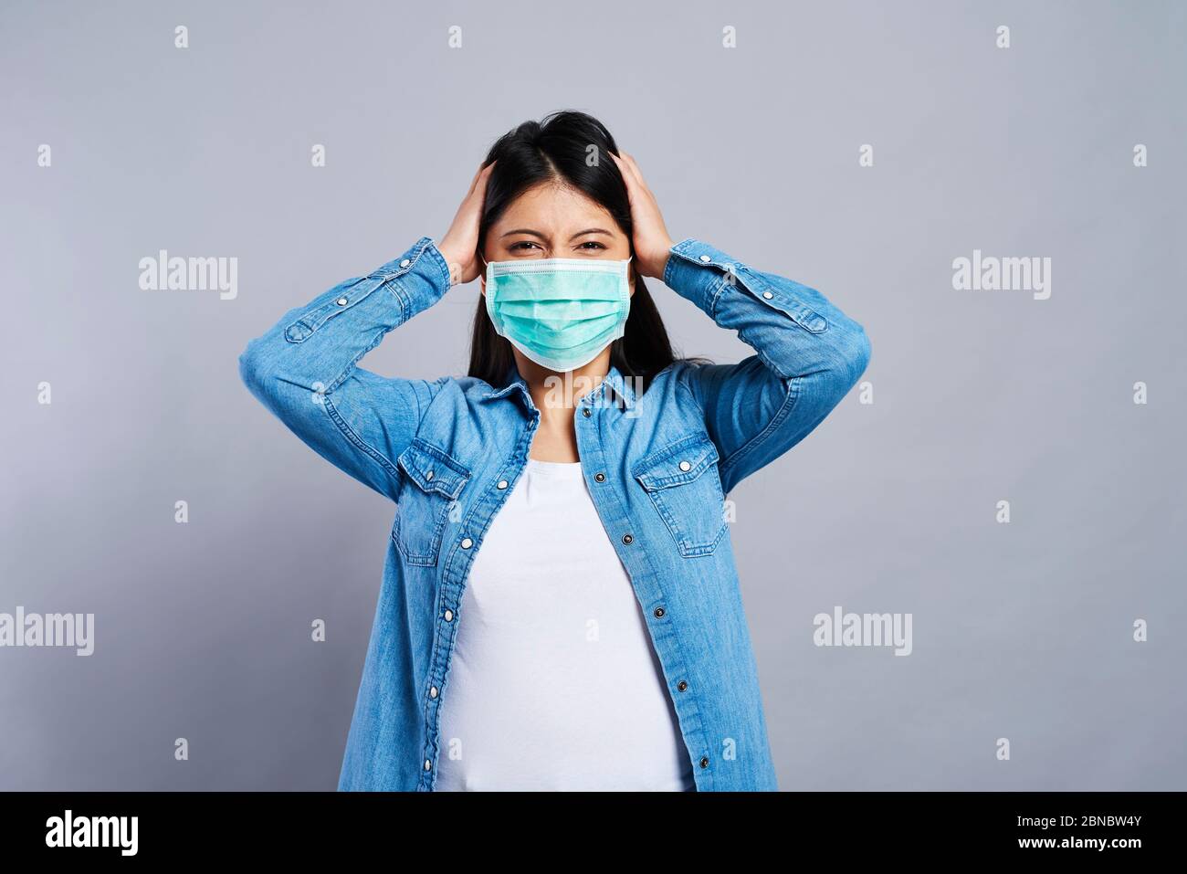 Paranoid Asian woman in protective mask Stock Photo