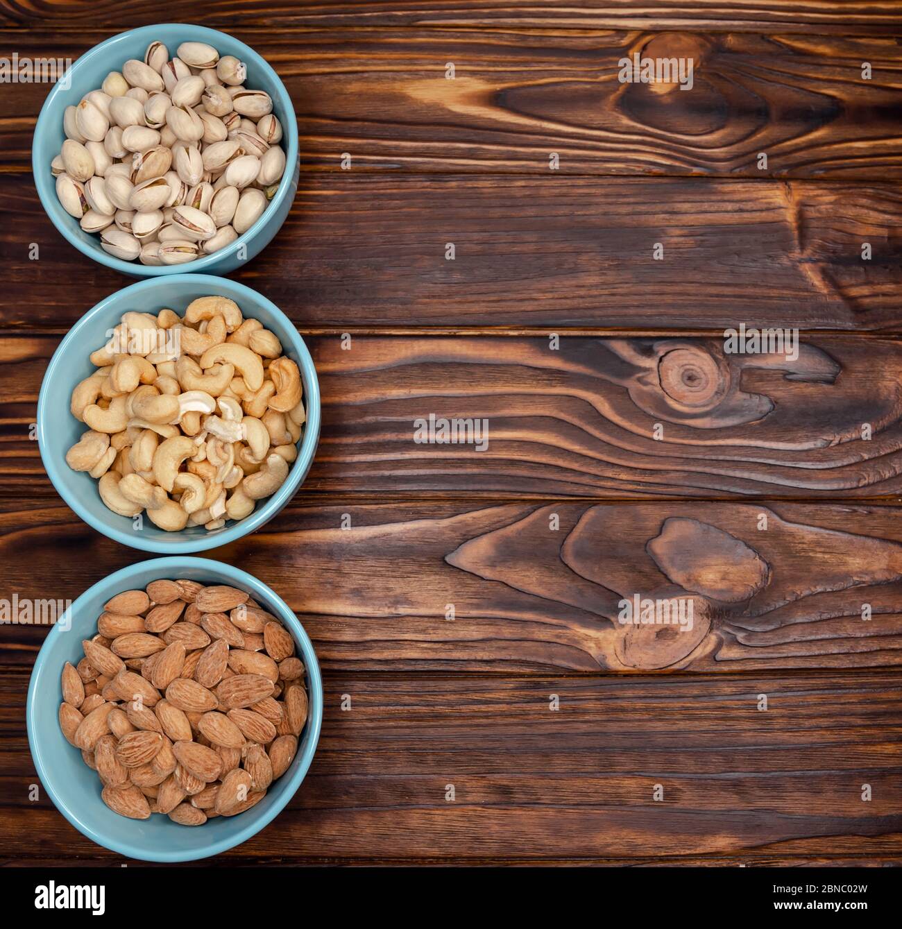 Different types of nuts in bowls. Almonds, pistachios, cashews Flatly