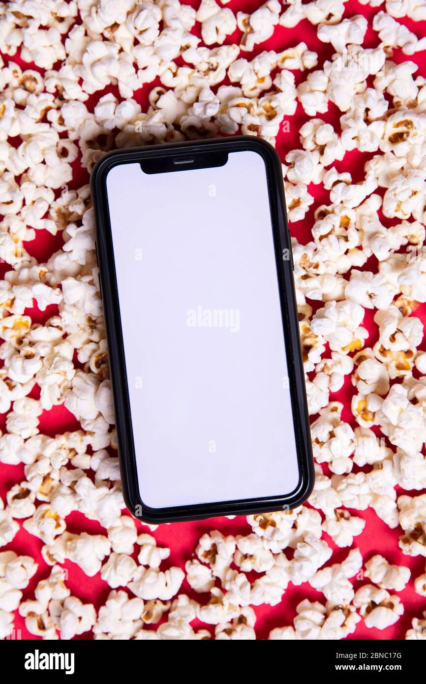 LONDON, UK - MAY 14 2020: Apple iphone blank screen with cinema popcorn Stock Photo