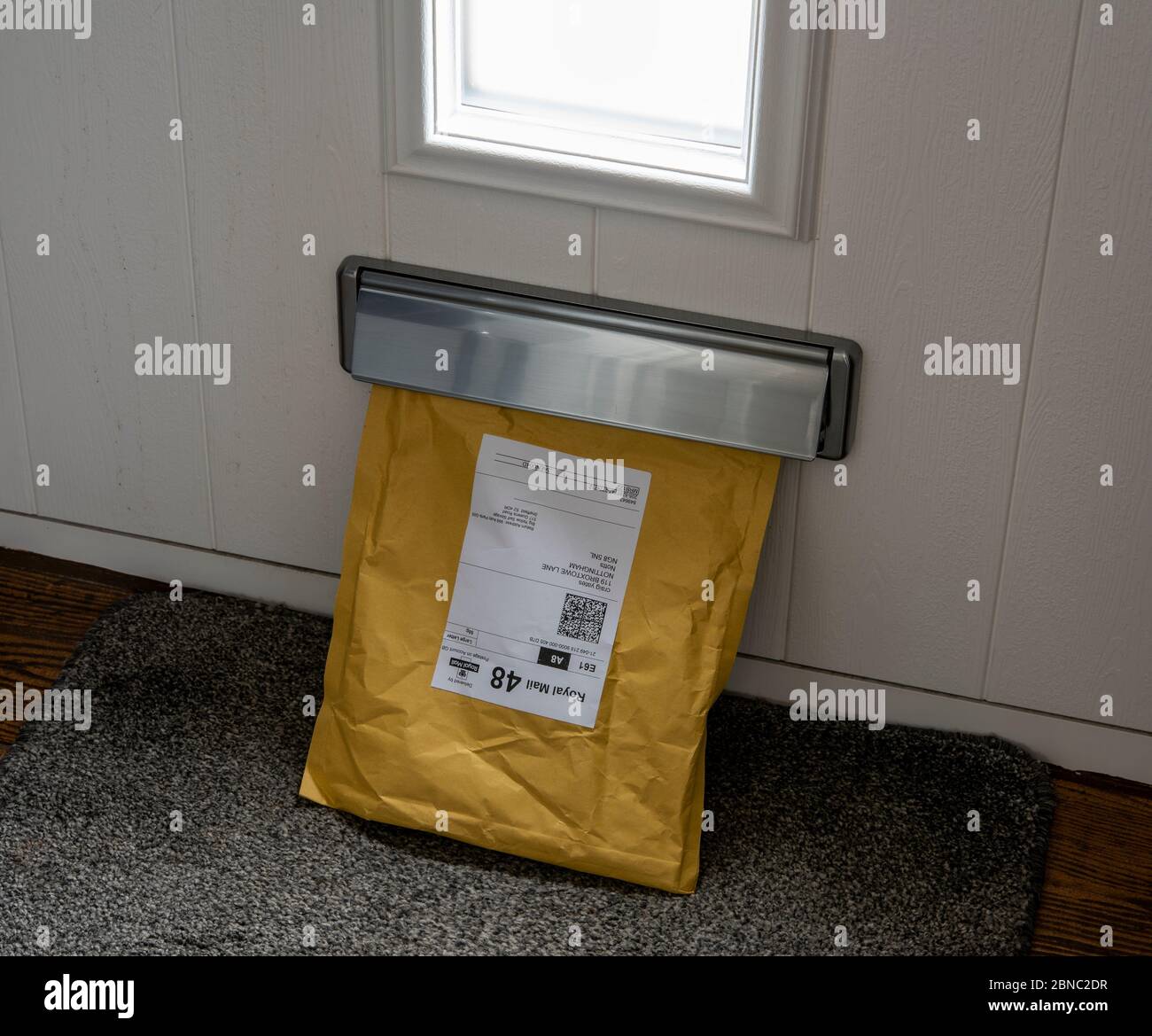 Letter size parcel coming through a domestic letter box uk Stock Photo