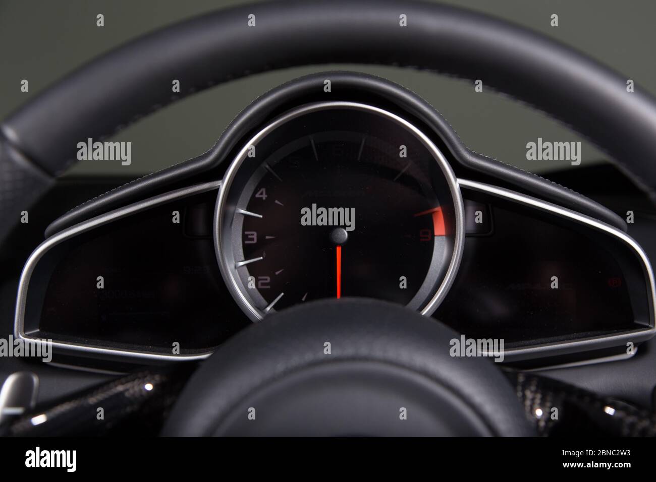 Closeup of a speedometer and a steering wheel of a modern car under the ...