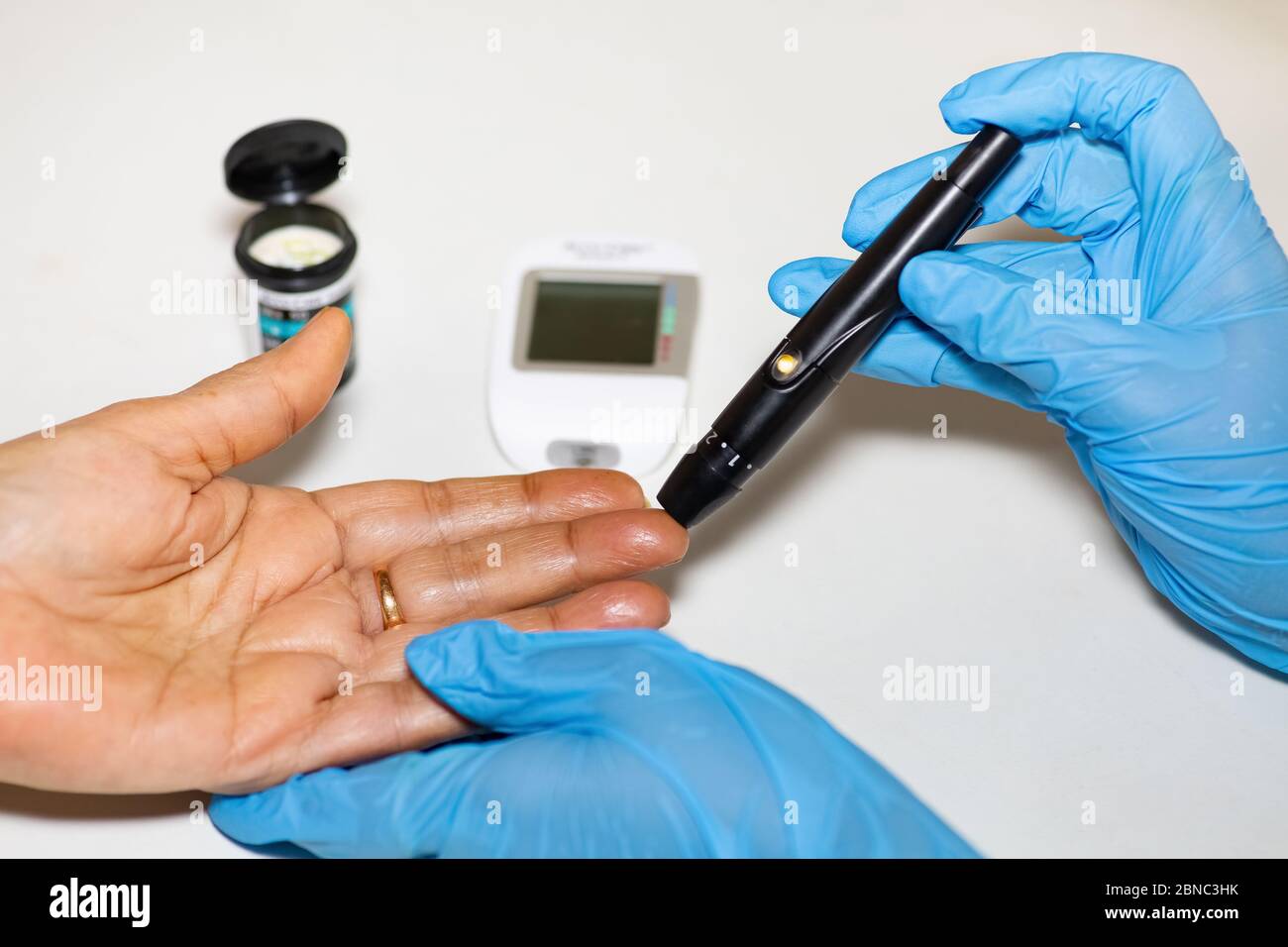 Nurse taking blood sample from a patient using a to measure