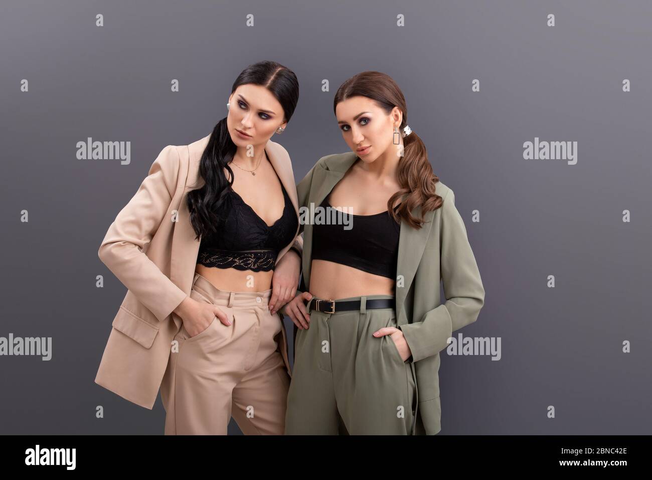 portrait of Two attractive business women wearing in suits and tops ...