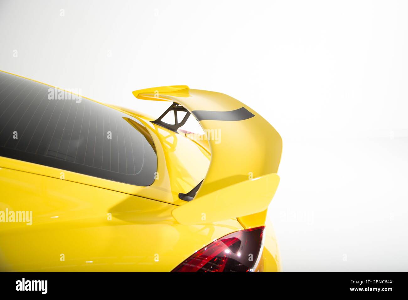 Closeup of a spoiler on a yellow modern car under the lights isolated on a white background Stock Photo