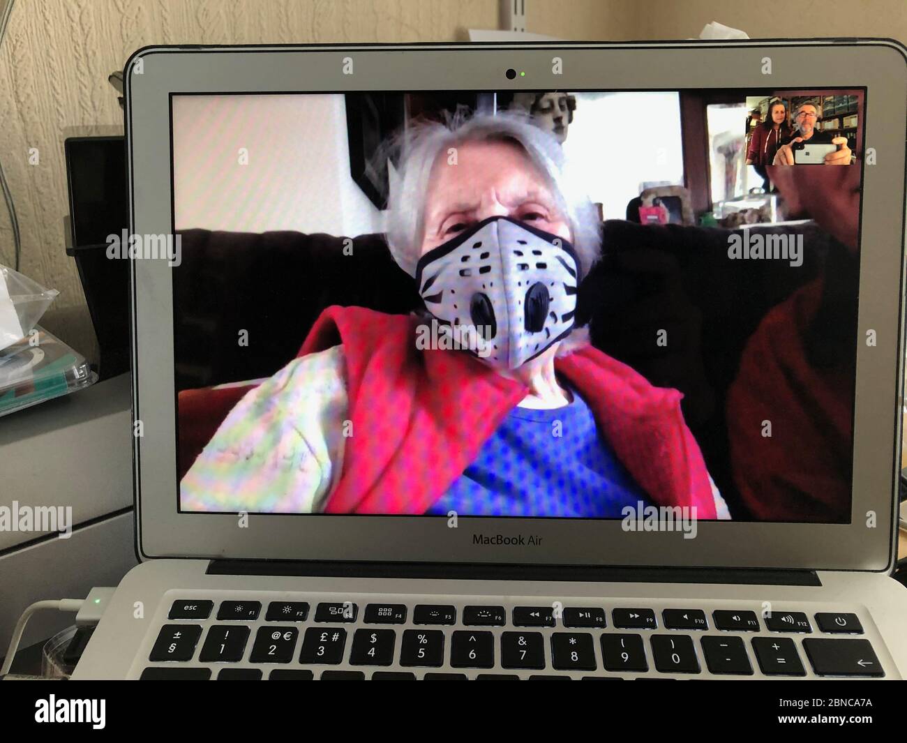 Photographer's 90 year old mother showing off her new face mask on a Facetime call during Coronavirus lockdown. UK 2020. MR Stock Photo